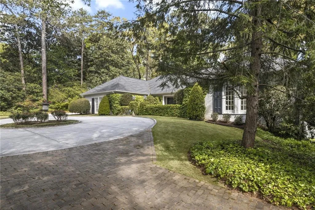 Brick drive off front driveway leads to additional parking in front of tennis court