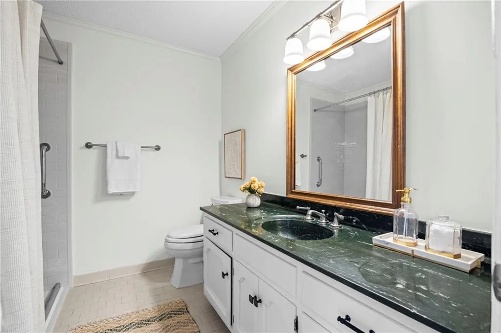 Full bathroom with vanity, walk-in shower, and light tile