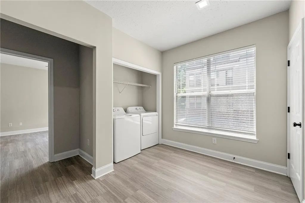 Laundry room with separate washer and dryer and light hardwood / wood-style floors