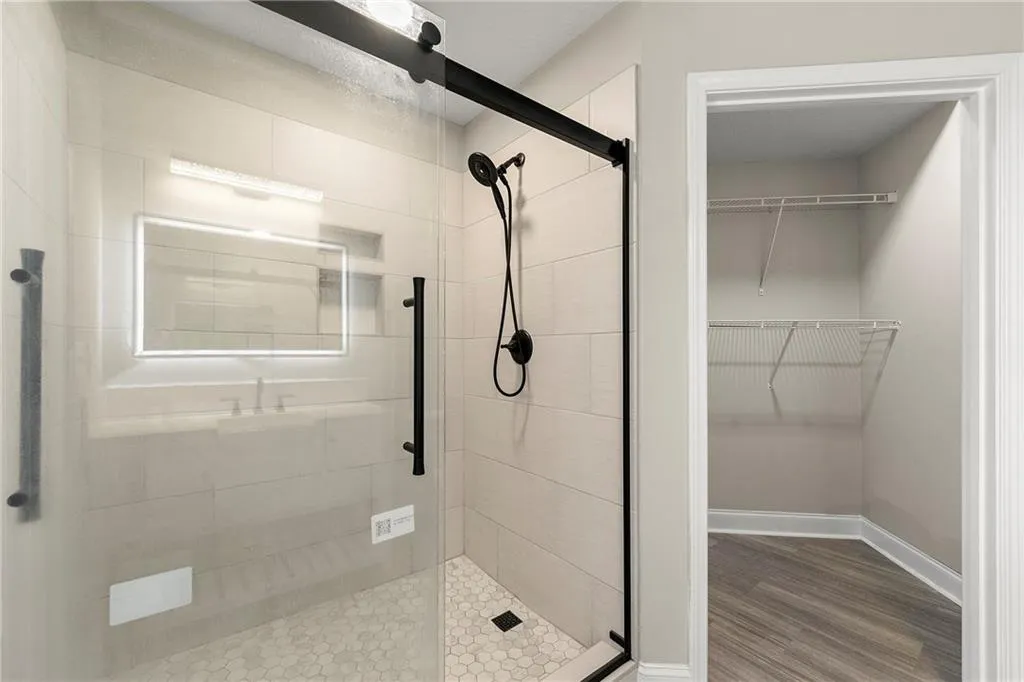 Bathroom featuring a shower with shower door and hardwood / wood-style flooring