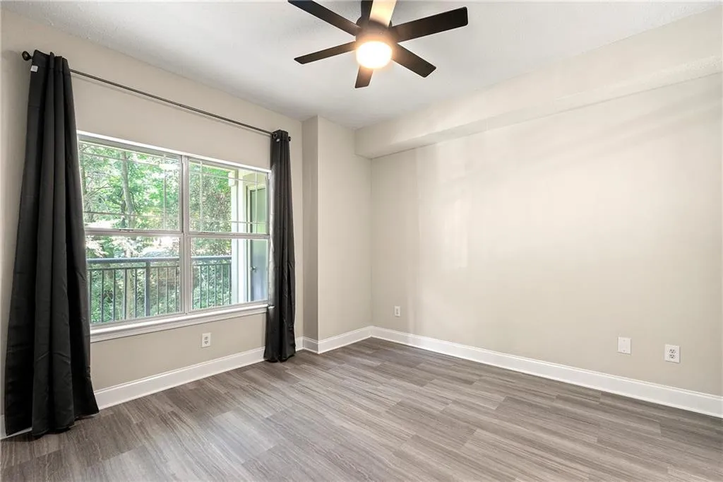 Spare room featuring plenty of natural light, ceiling fan, and wood-type flooring