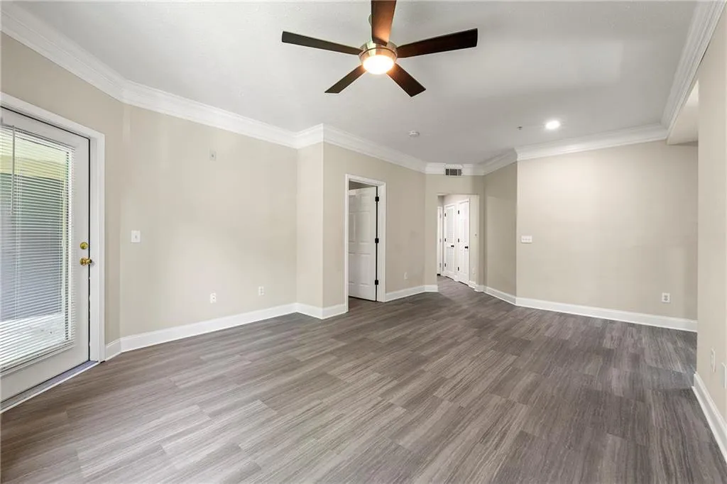 Unfurnished room featuring wood-type flooring, ornamental molding, and ceiling fan