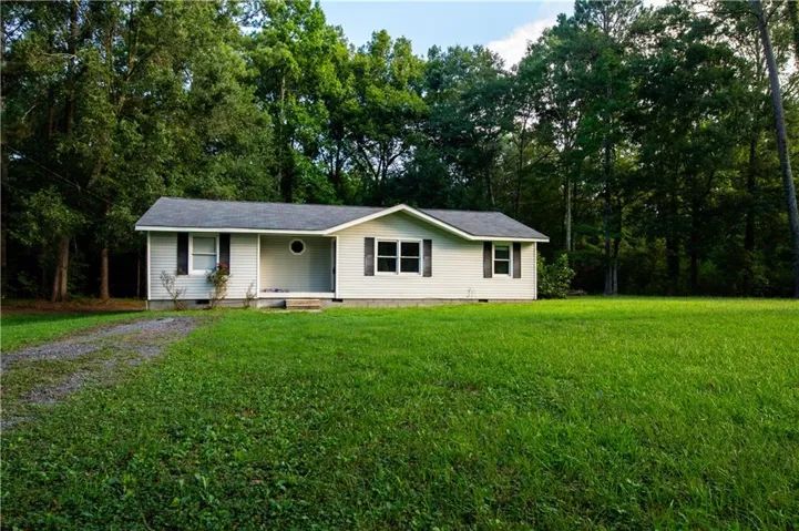 Single-story residence featuring light-colored siding and a dark-toned roof