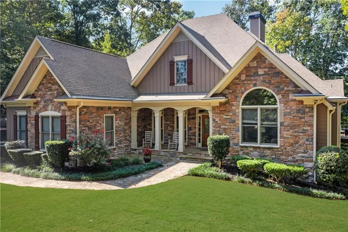 Craftsman-style home with a porch, a front yard, board and batten siding, and a shingled roof
