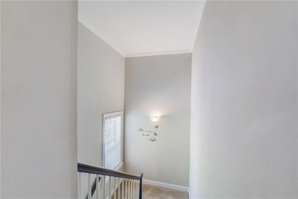 Stairway featuring light colored carpet