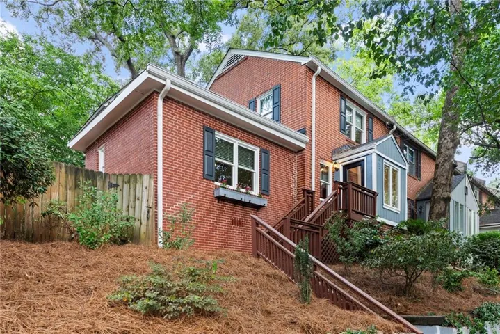 Brick exterior with black louvered shutters, white window frames, and a window box