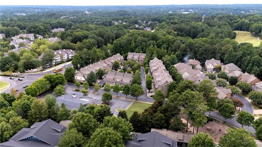 Aerial perspective showcasing a residential community with abundant mature trees and a park area