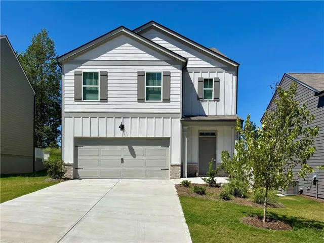Contemporary exterior with white siding, board and batten accents, and a two-car garage