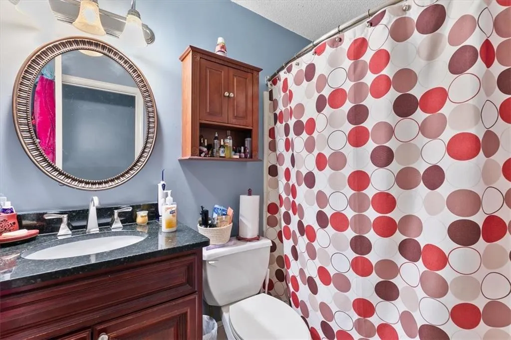 Bathroom featuring vanity, toilet, and a textured ceiling