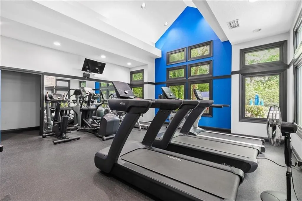 Gym featuring a healthy amount of sunlight and a towering ceiling