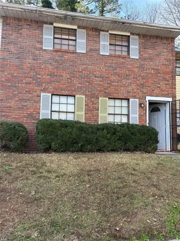 View of front of house featuring a front lawn and brick siding