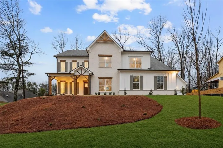 White brick and board-and-batten exterior with a covered front porch featuring wood beams