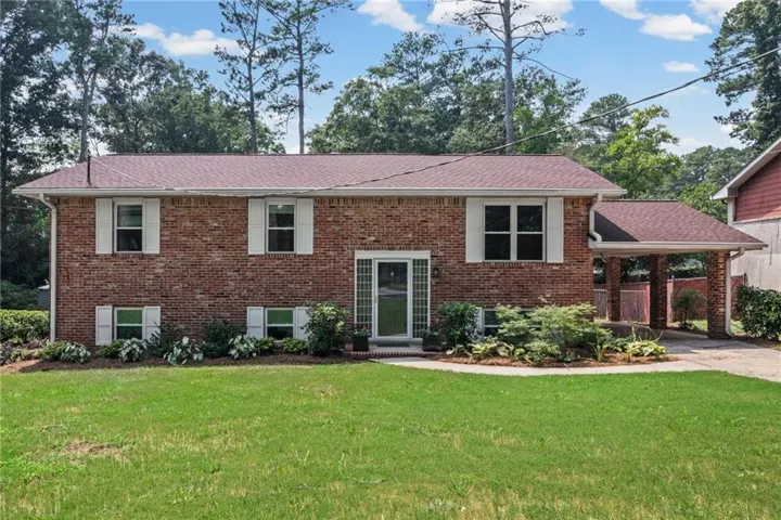 Brick exterior with white window shutters and a covered carport