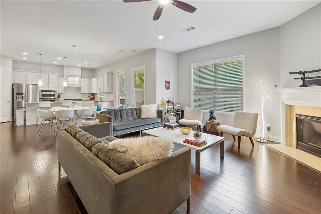 Living room featuring hardwood floors, a premium fireplace, and ceiling fan