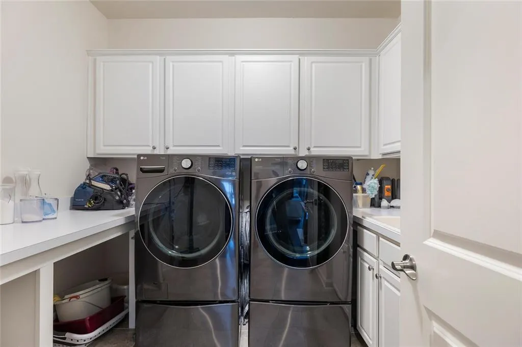 Clothes washing area featuring cabinets