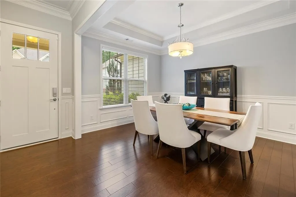 Dining room with crown molding, tray ceiling, and hardwood flooring