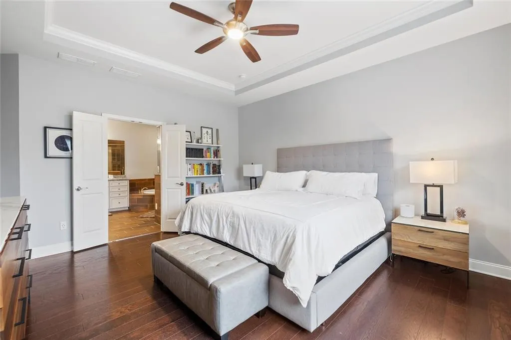 Bedroom featuring  hardwood floors, ceiling fan, tray ceiling, and crown molding