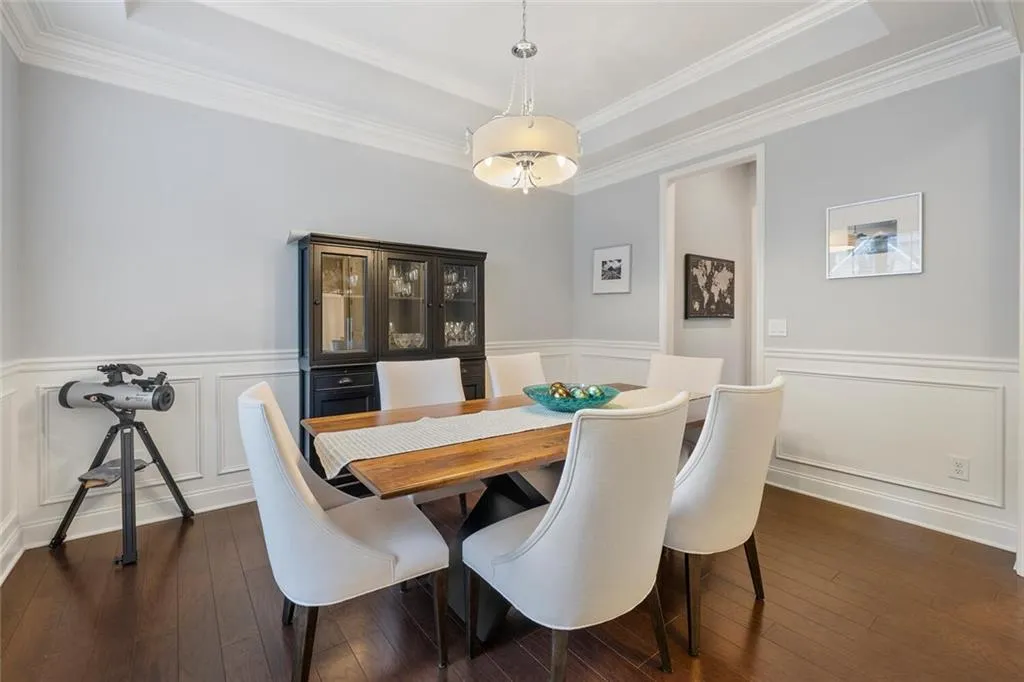 Dining room with crown molding, tray ceiling, and hardwood flooring