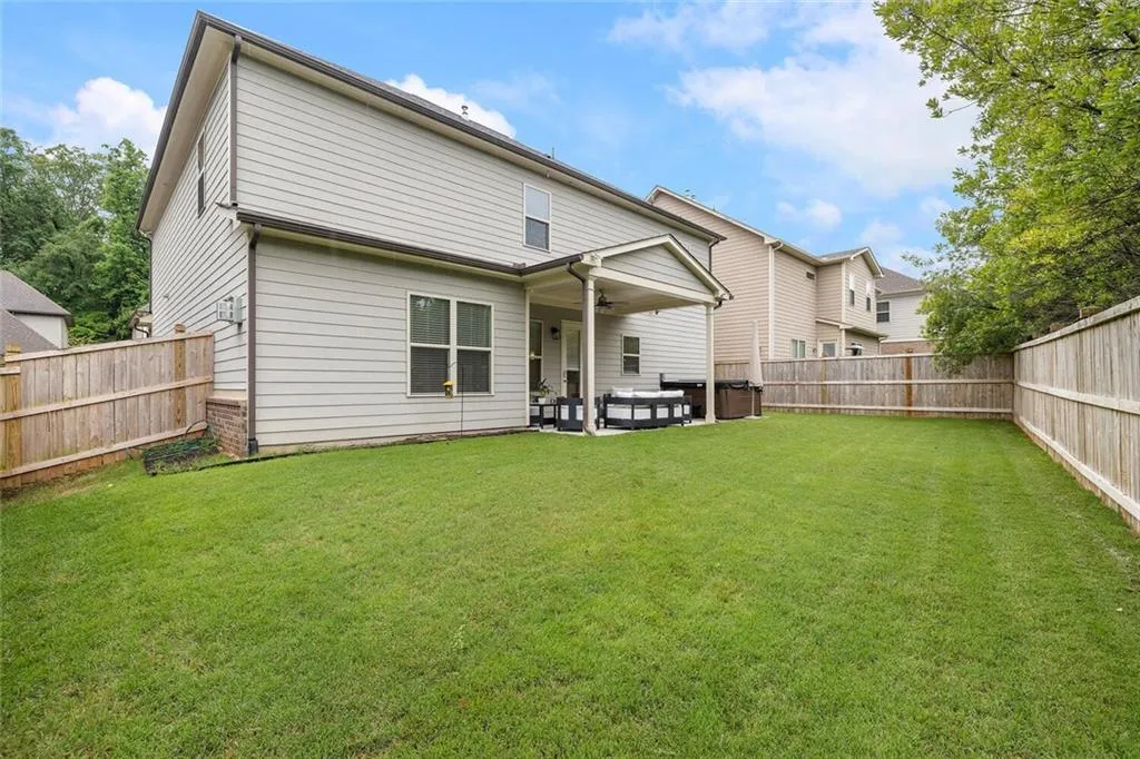Rear view of property featuring a patio and a yard