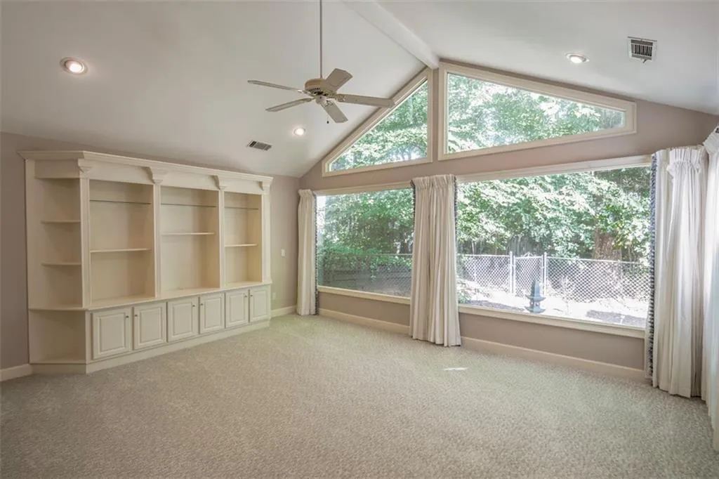 Unfurnished living room featuring plenty of natural light and carpet flooring