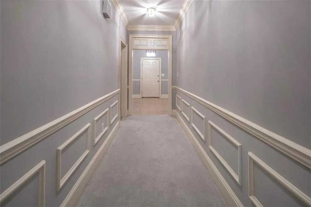 Corridor featuring light carpet and ornamental molding
