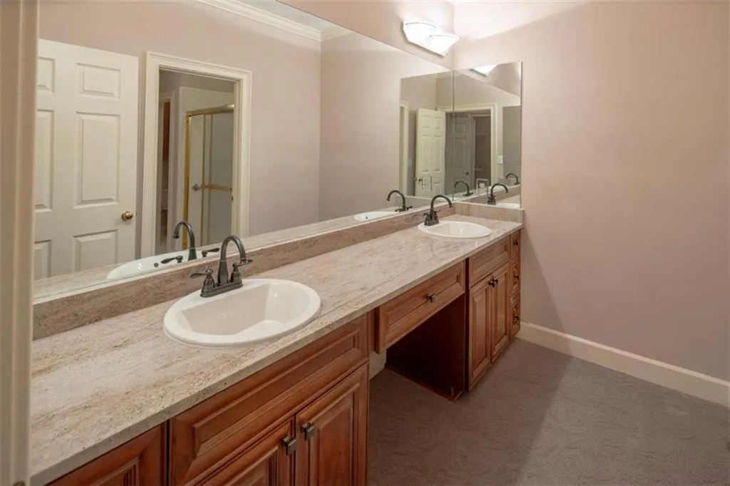 Bathroom featuring crown molding, double sink, and large vanity