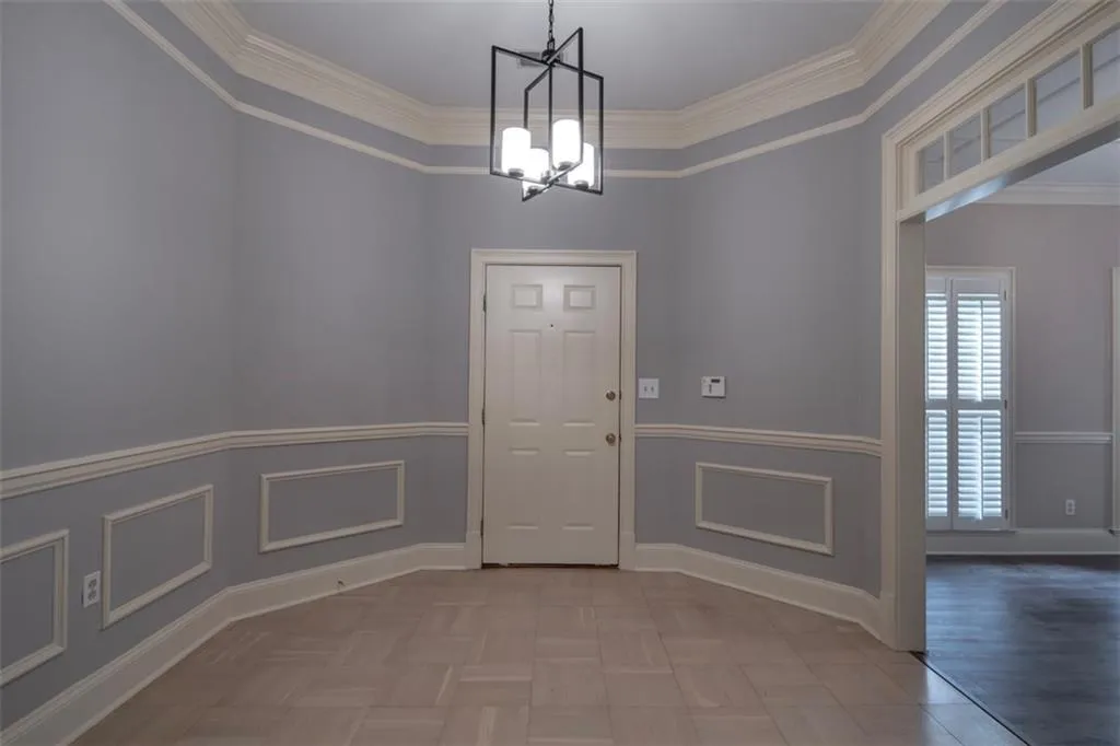 Entryway featuring crown molding and an inviting chandelier
