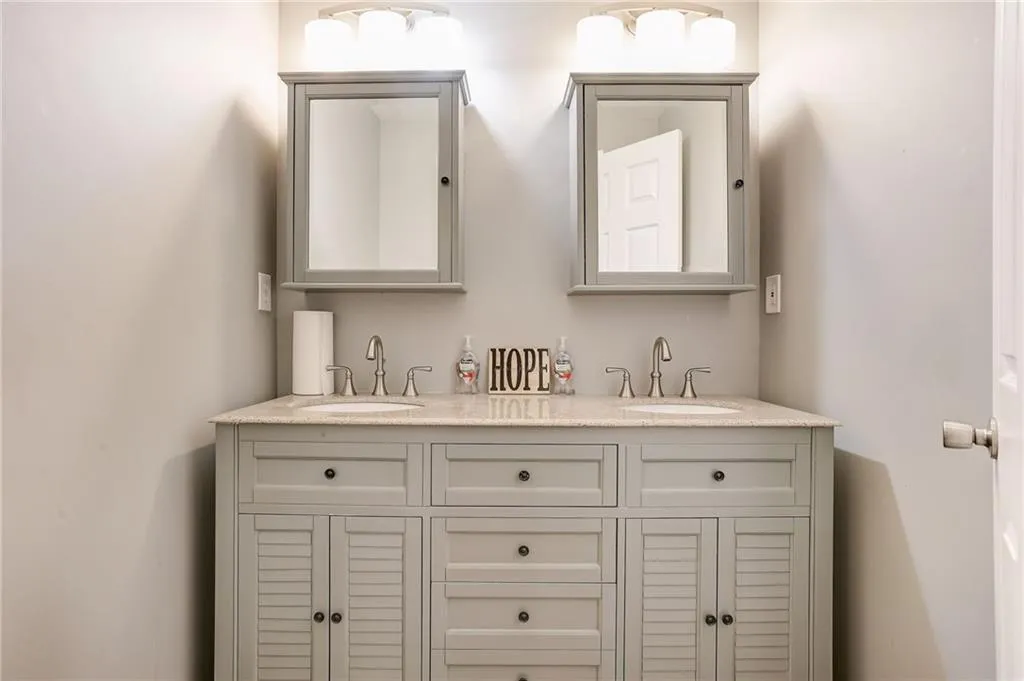 Bathroom featuring double sink and vanity with extensive cabinet space