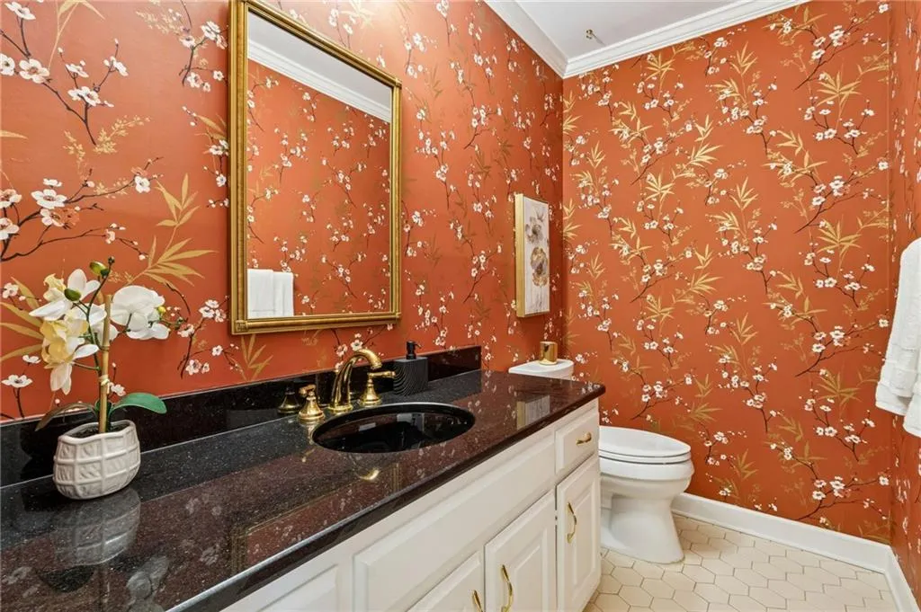 Half bath with vanity, wallpapered walls, light tile patterned flooring, and ornamental molding