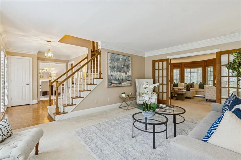 Living area featuring carpet flooring, french doors, and crown molding
