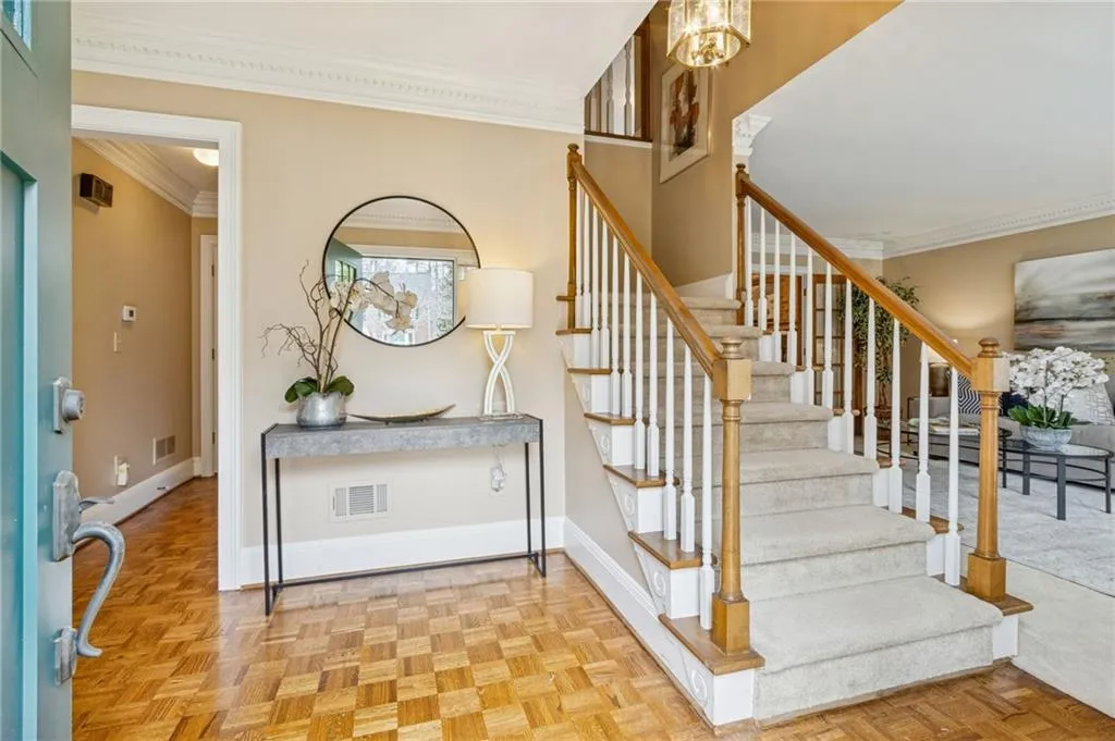 Foyer with parquet flooring and crown molding