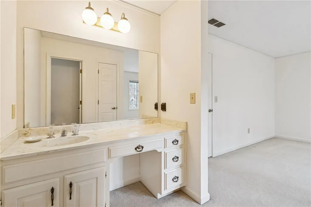 Bathroom featuring light colored carpet and vanity
