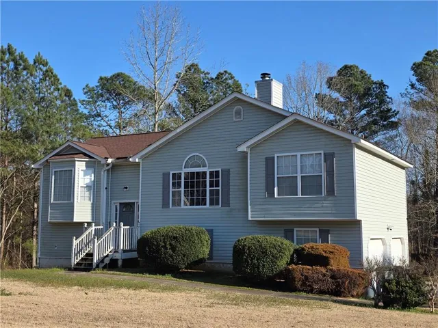 Split foyer home featuring a chimney and a front lawn