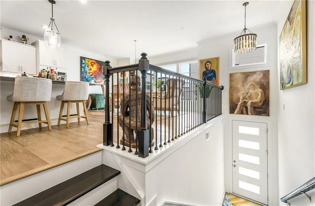Foyer entrance with light wood-style flooring, ornamental molding, and a chandelier