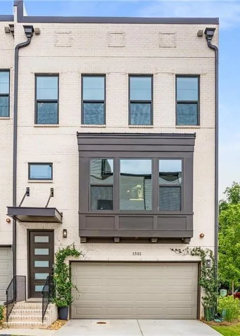 View of front facade featuring a garage, brick siding, and concrete driveway
