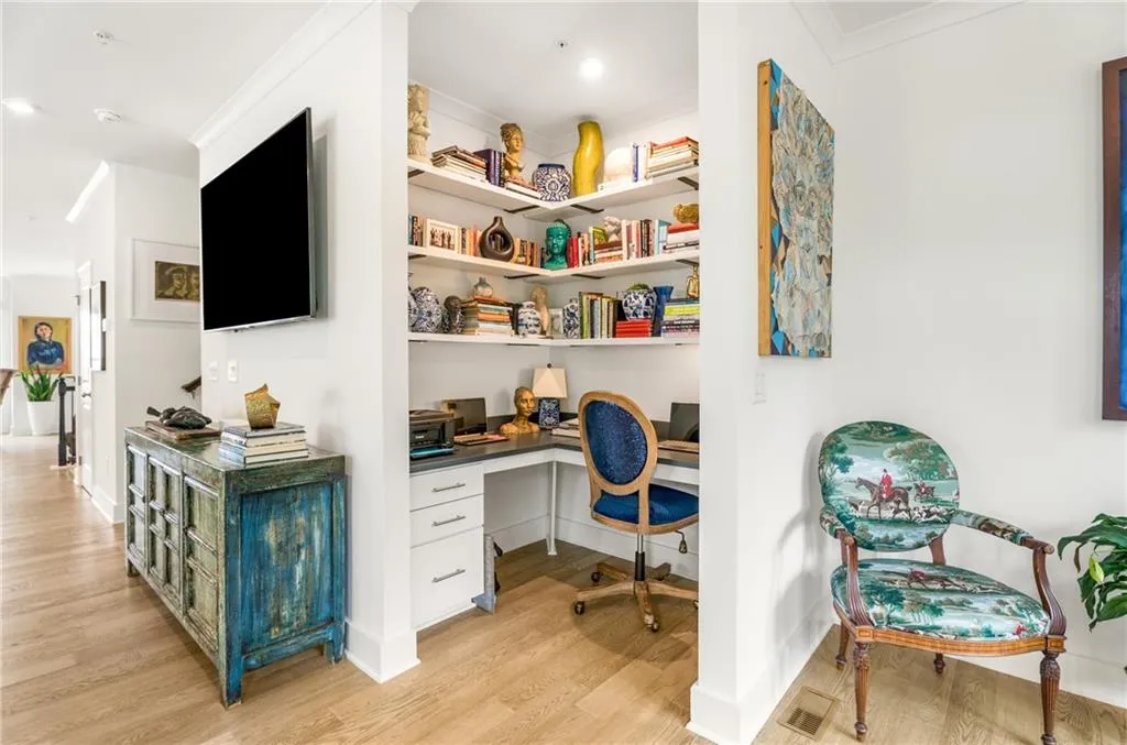 Office space featuring built in study area, light wood-type flooring, and ornamental molding