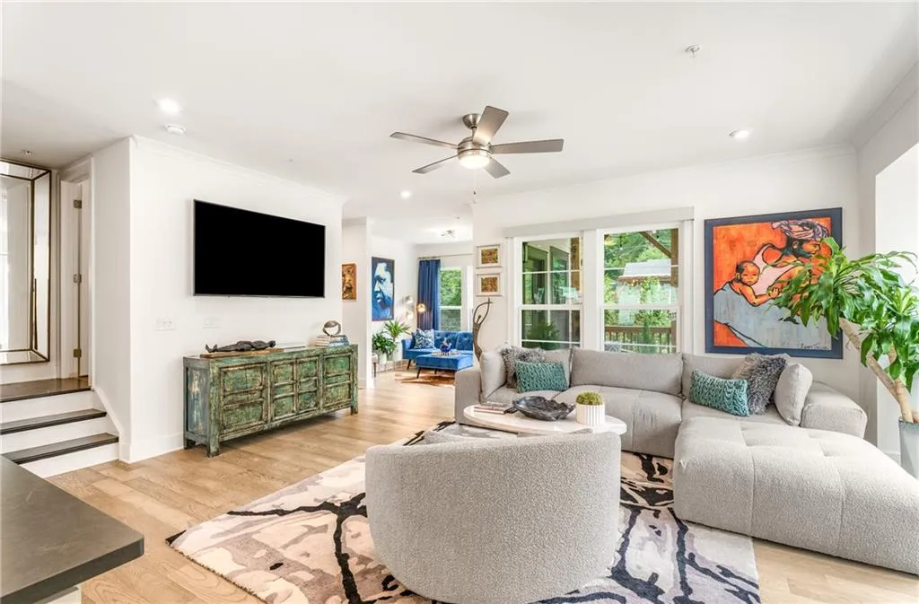 Living area featuring wood finished floors, ornamental molding, a ceiling fan, recessed lighting, and stairs