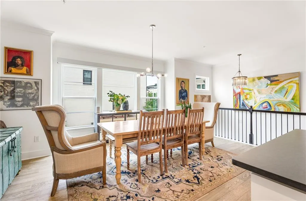 Dining area with a chandelier, light wood-style flooring, and crown molding
