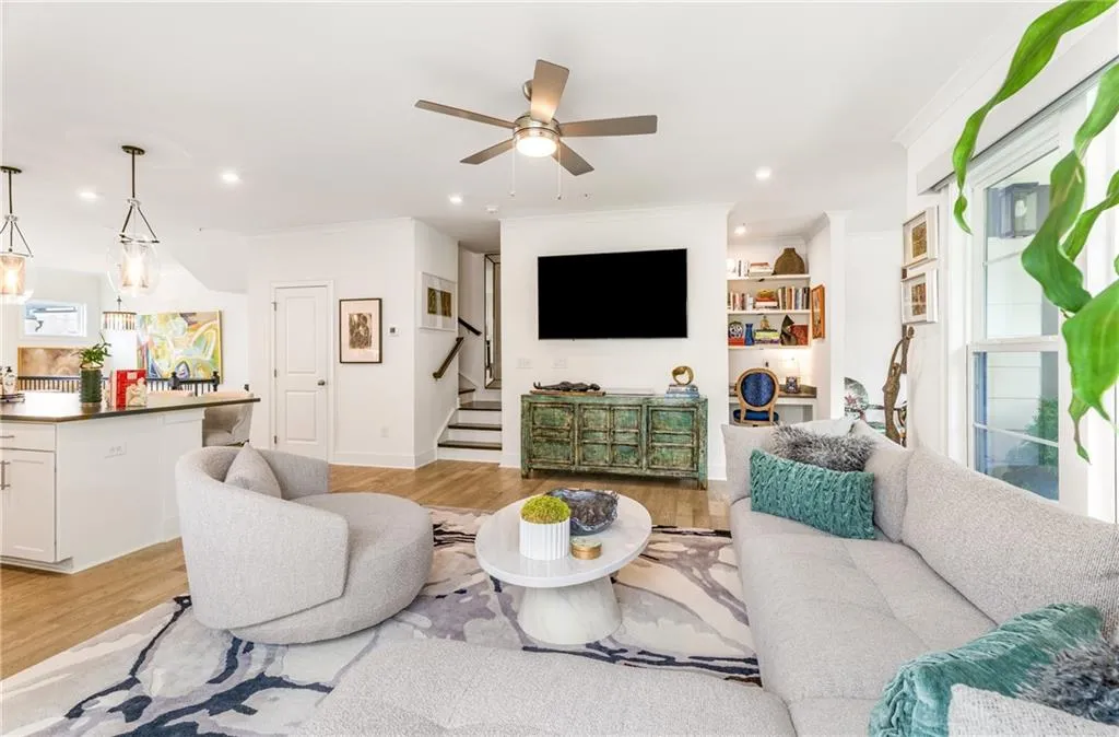 Living area featuring light wood-style flooring, stairs, ornamental molding, recessed lighting, and ceiling fan