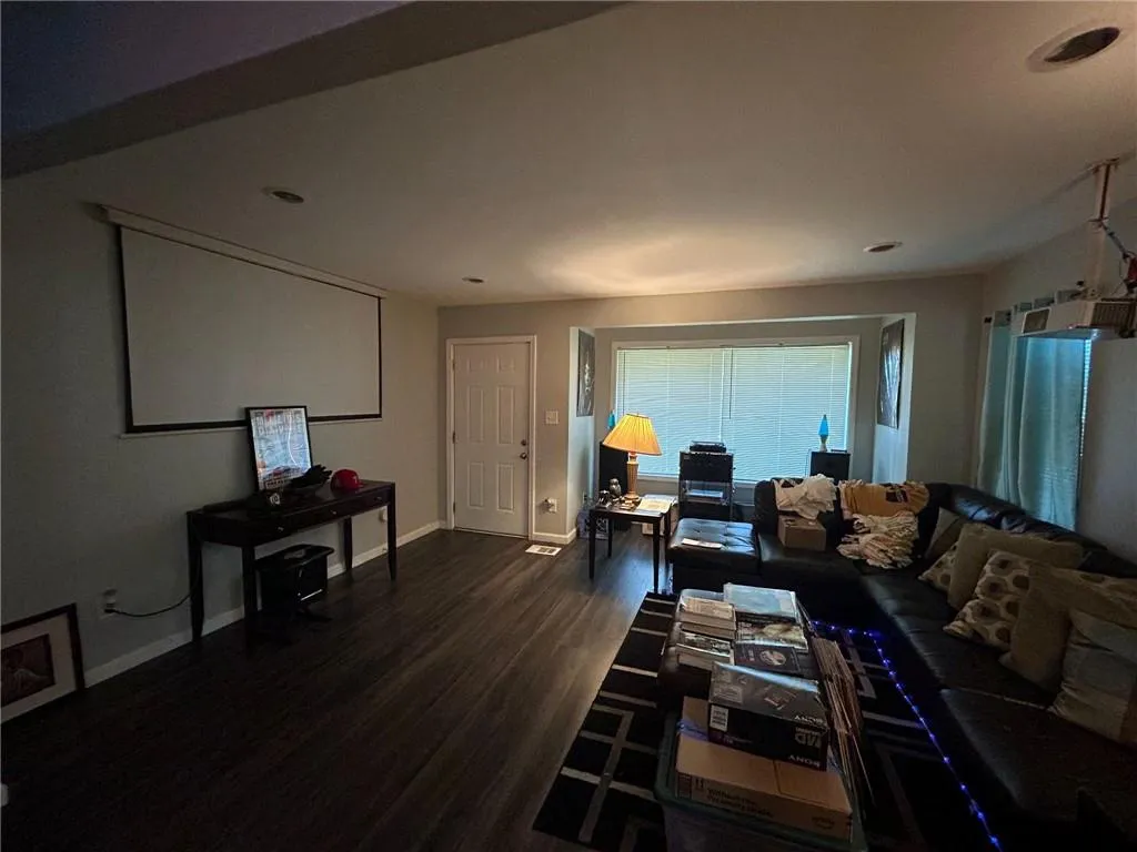 Living area with dark wood-style floors and recessed lighting
