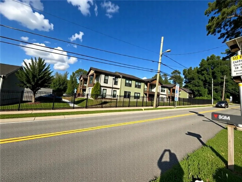 View of asphalt street with sidewalks, street lights, and curbs