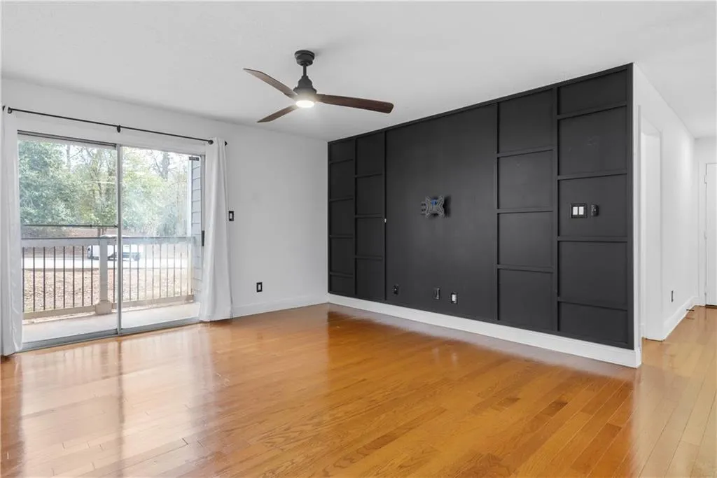 Spare room with ceiling fan, light wood-style flooring, and baseboards