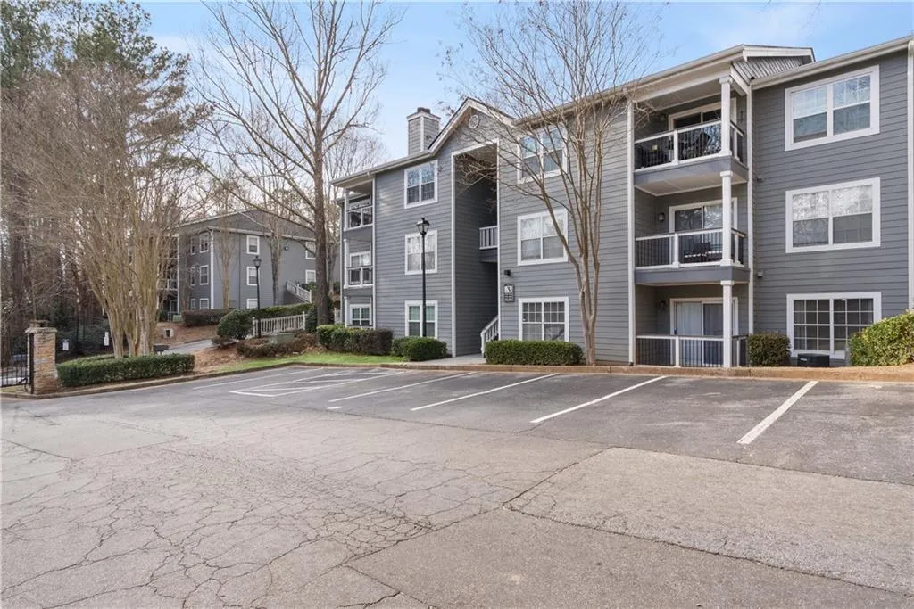 View of building exterior featuring uncovered parking
