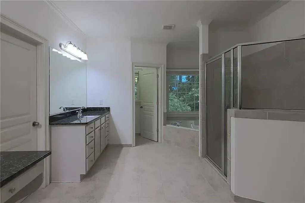 Full bath featuring vanity, a stall shower, and a garden tub