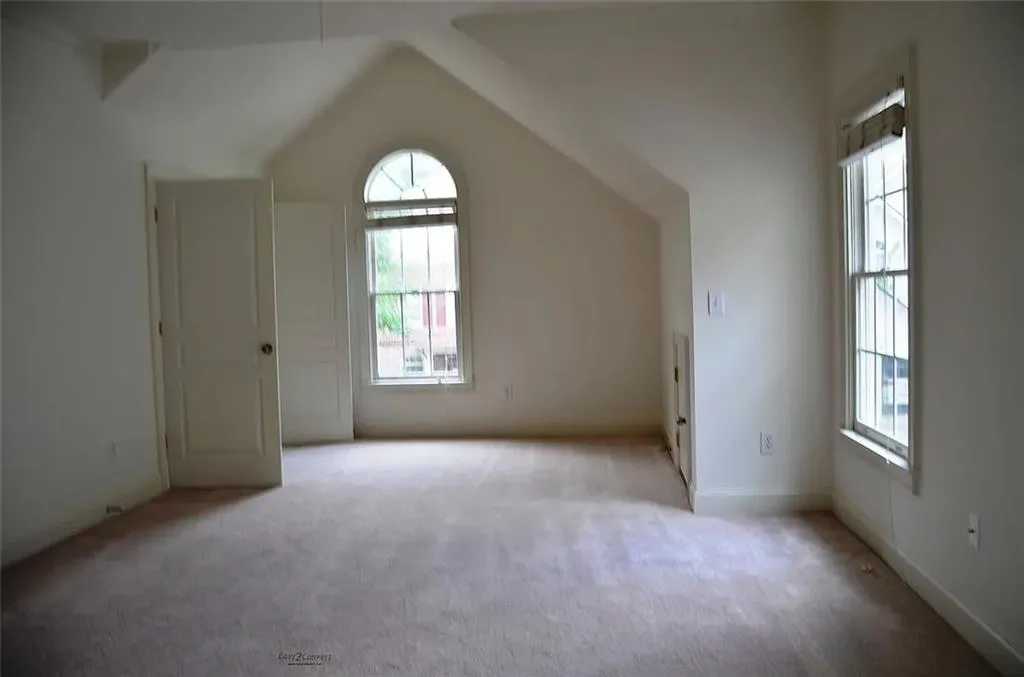 Additional living space with carpet floors and vaulted ceiling