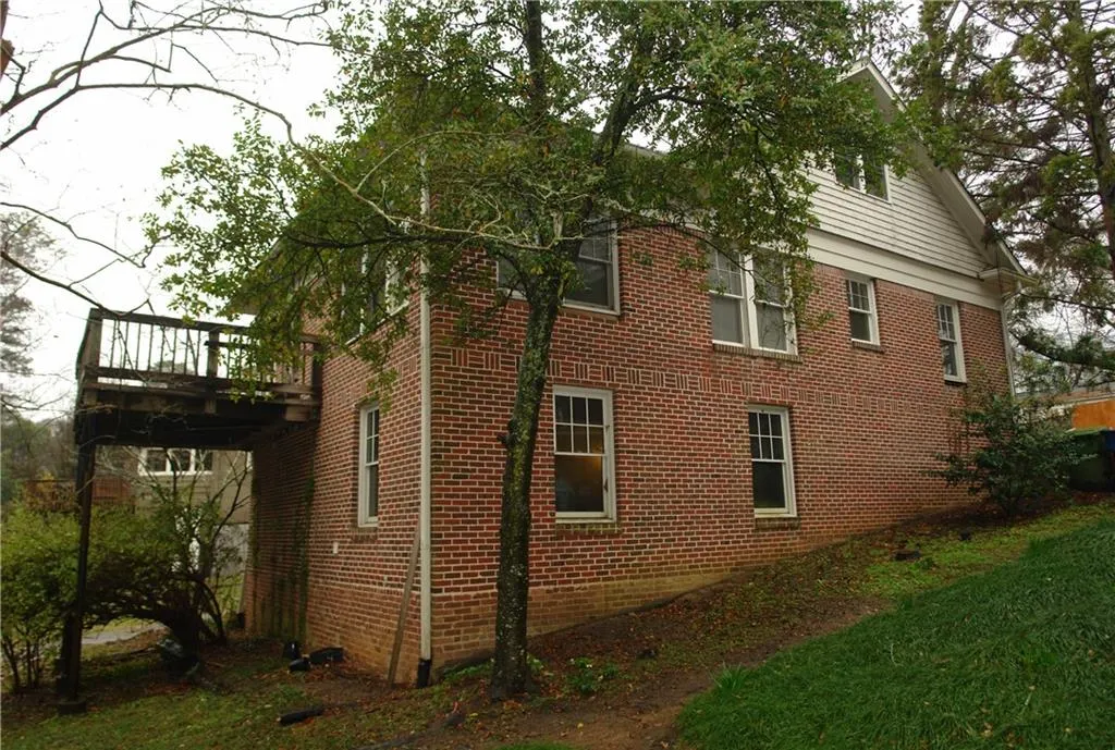 View of side of property with brick siding and a wooden deck