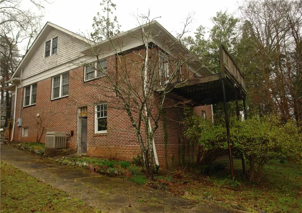 Back of house featuring brick siding and a deck