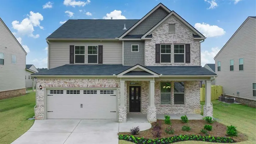 Craftsman-style home with covered porch, a front lawn, concrete driveway, an attached garage, and brick siding