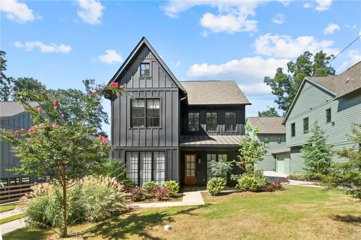 Modern farmhouse exterior featuring dark vertical siding and a prominent gable roofline