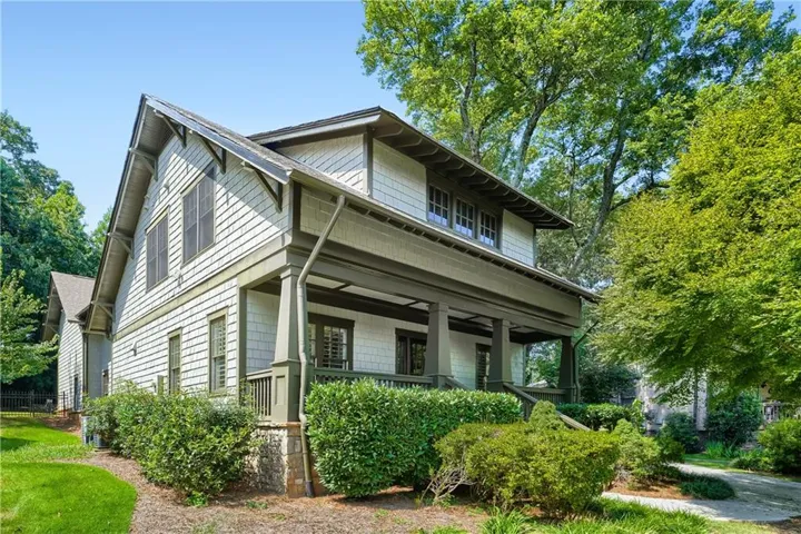 Craftsman-style exterior featuring shingle siding, a covered porch, wood columns, and a gabled roofline